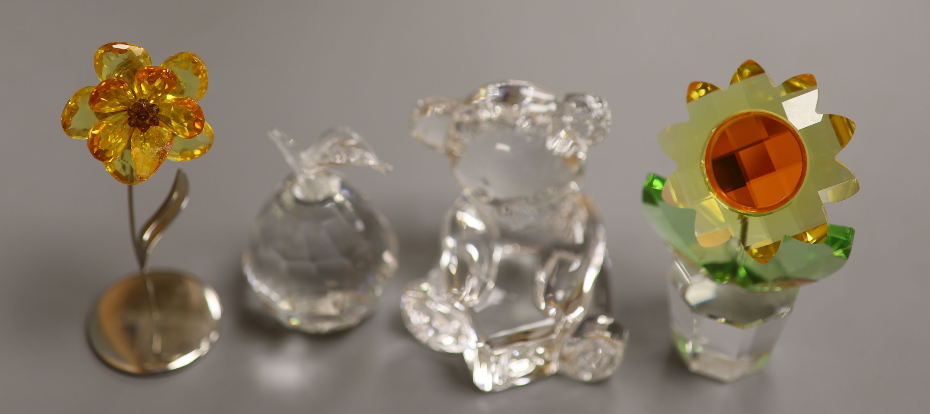 A Swarovski 'Sunflower', with topaz centre and yellow petals in clear glass pot (boxed), a smaller yellow flower and a Waterford crystal teddy bear